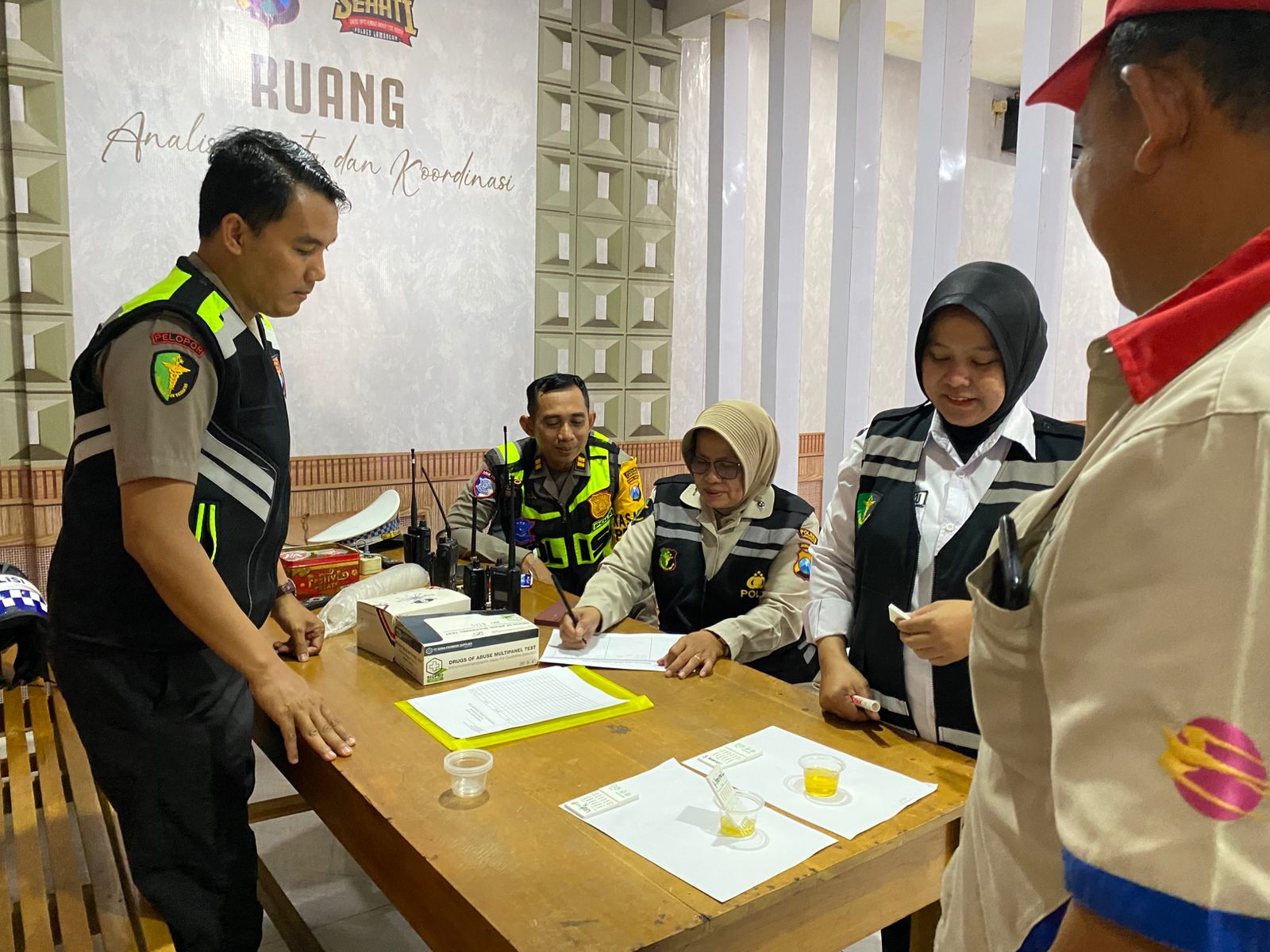 Foto : Personel Sie Dokkes Polres Lamongan melakukan pengambilan sampel urine terhadap seorang pengemudi bus untuk uji narkoba.